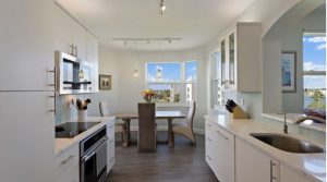 Kitchen with white cabinets and counters, and new appliances