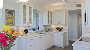 An updated kitchen with white cabinets and counters