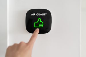 Finger pointing to a button that has a green thumbs up and and air quality text 